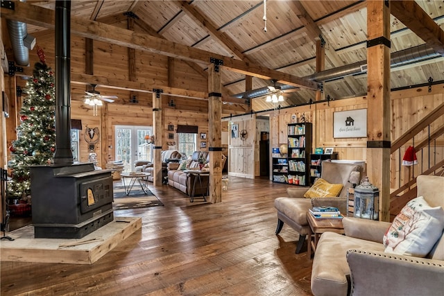 living room with wood ceiling, a wood stove, wooden walls, and beam ceiling