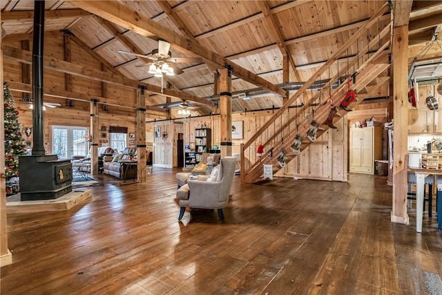 unfurnished living room with beam ceiling, high vaulted ceiling, wooden walls, and wooden ceiling