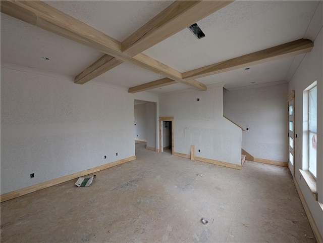 empty room with beam ceiling and baseboards