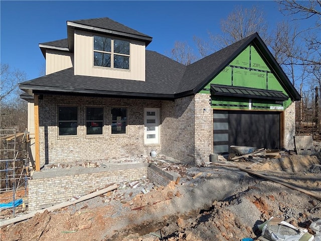 view of front of home featuring board and batten siding, a garage, brick siding, and roof with shingles