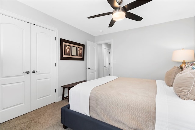 bedroom featuring ceiling fan, a closet, and light colored carpet