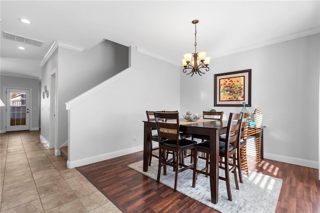 dining space featuring crown molding, a notable chandelier, and hardwood / wood-style flooring