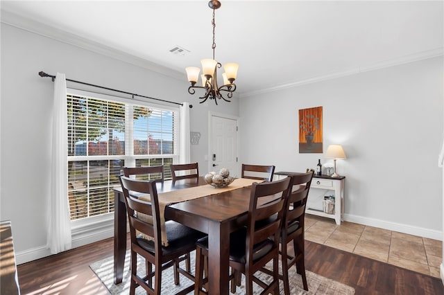 dining area with crown molding, dark wood-type flooring, and a notable chandelier