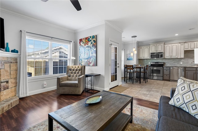 living room with hardwood / wood-style floors, ceiling fan, sink, and crown molding