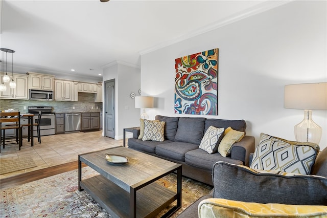 living room featuring light hardwood / wood-style floors, ornamental molding, and sink