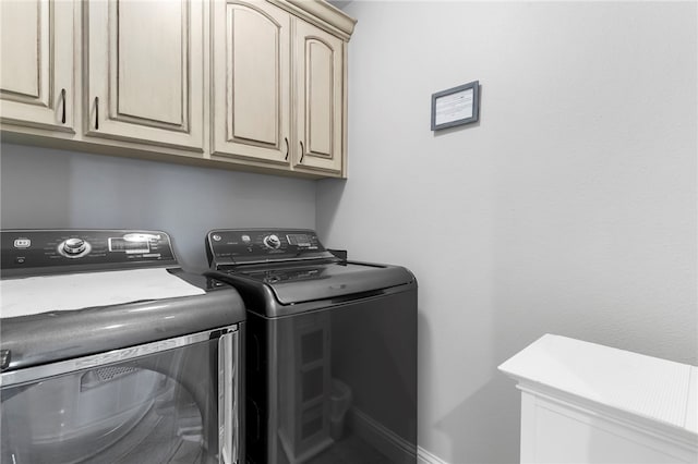 laundry area featuring washer and dryer and cabinets