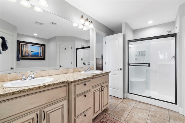 bathroom featuring tile patterned flooring, vanity, and a shower with shower door