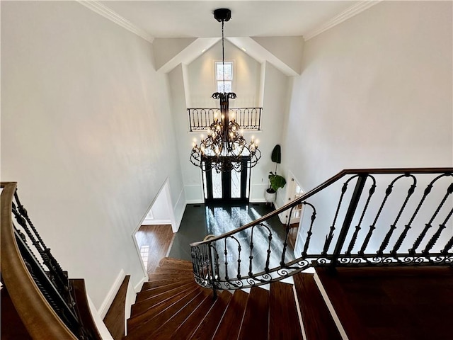 stairs featuring hardwood / wood-style floors, ornamental molding, and an inviting chandelier