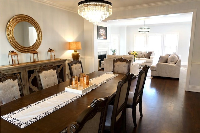 dining room featuring dark hardwood / wood-style floors, an inviting chandelier, and crown molding