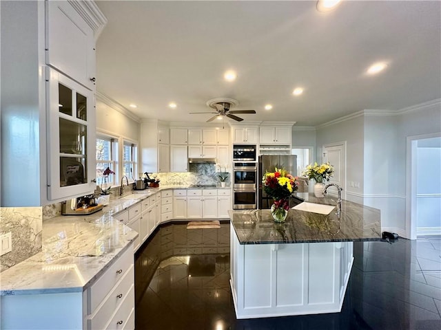 kitchen featuring appliances with stainless steel finishes, white cabinetry, ornamental molding, and sink