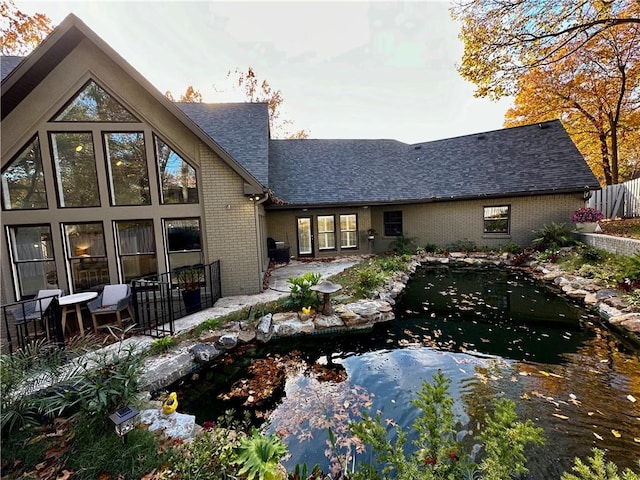 back of property with a garden pond