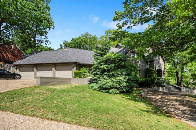 view of front of property with a garage, roof with shingles, concrete driveway, and a front lawn