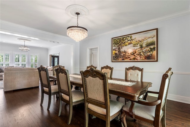 dining area with crown molding, dark wood finished floors, and a chandelier