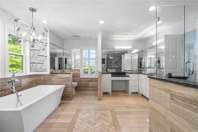 bathroom with vanity, plenty of natural light, a soaking tub, and a shower stall
