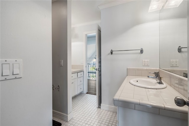 bathroom featuring crown molding, baseboards, and vanity