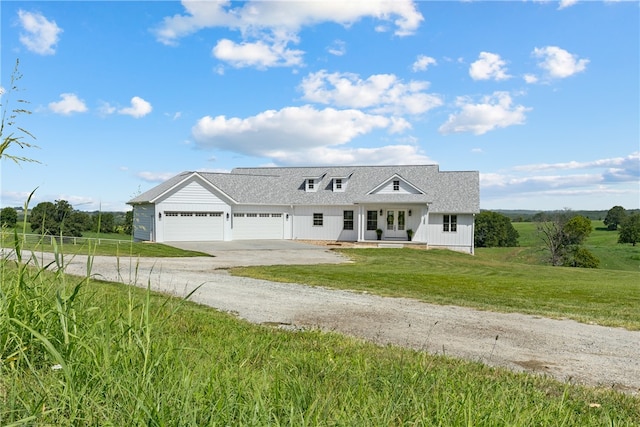 view of front of house with a porch, a garage, and a front lawn