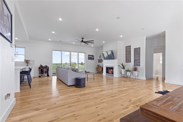 living room with ceiling fan and light wood-type flooring