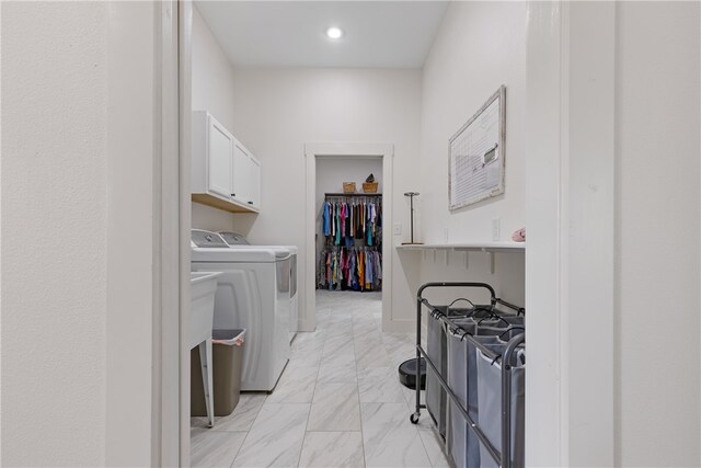 clothes washing area with cabinets and washing machine and dryer