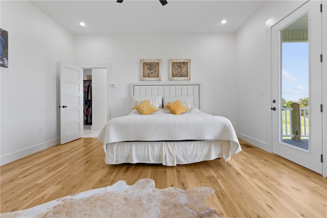 bedroom with access to outside, ceiling fan, light hardwood / wood-style flooring, and a spacious closet