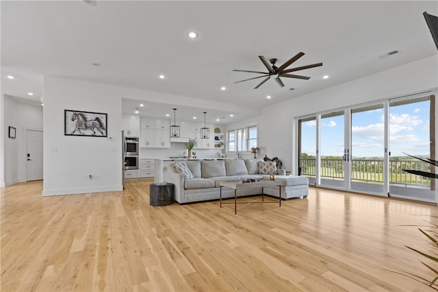 living room featuring ceiling fan and light hardwood / wood-style floors