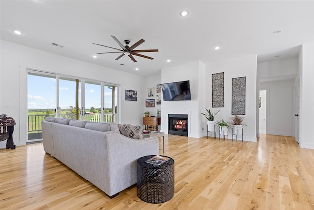 living room with ceiling fan and light wood-type flooring