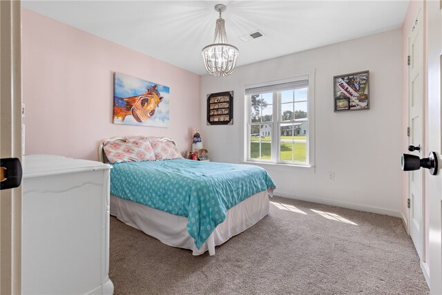 bedroom with light carpet and a chandelier