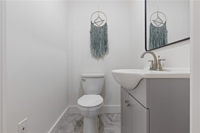 bathroom featuring tile patterned floors, vanity, and toilet