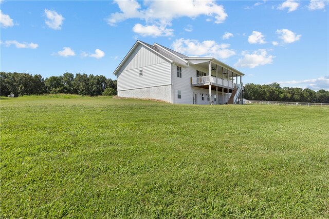 back of house featuring a lawn and a wooden deck