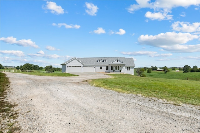 view of front facade with a rural view, a front yard, and a garage