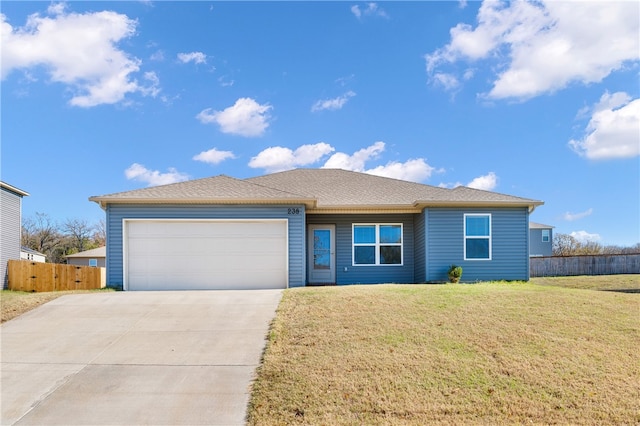 ranch-style house featuring a front yard and a garage