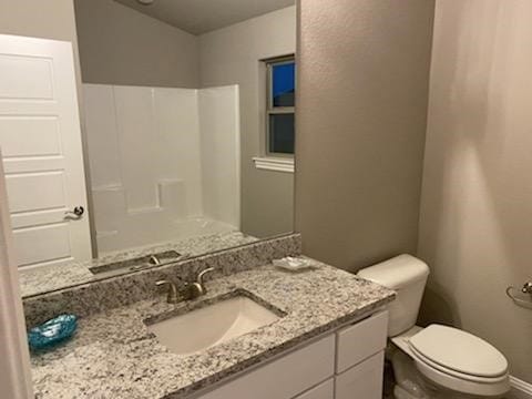 bathroom with a shower, vanity, and toilet