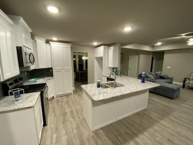 kitchen featuring electric stove, white cabinetry, and light stone counters