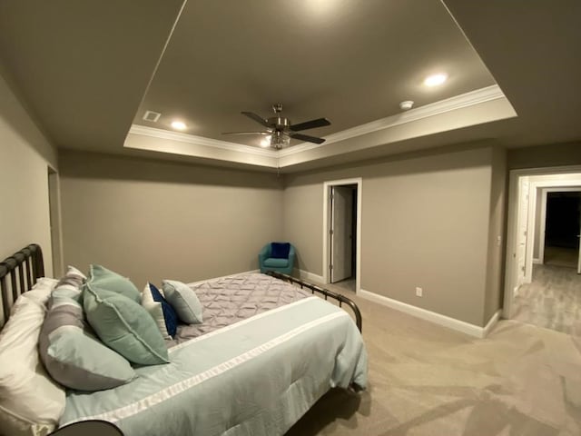 bedroom with a tray ceiling, crown molding, ceiling fan, and light colored carpet