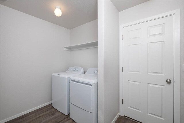 washroom featuring washing machine and clothes dryer and dark hardwood / wood-style floors