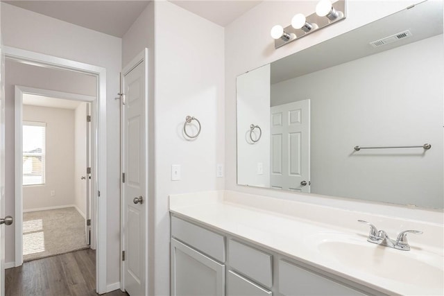 bathroom featuring vanity, wood finished floors, visible vents, and baseboards