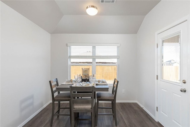 dining room with dark wood-style floors, baseboards, and vaulted ceiling