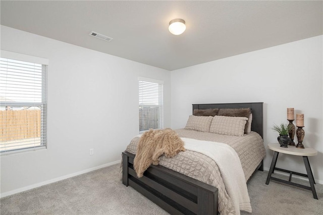 bedroom featuring baseboards, visible vents, and light carpet