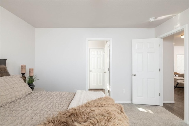 bedroom with baseboards and carpet