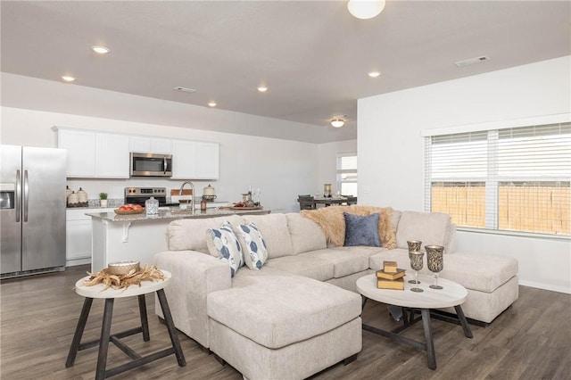 living area featuring recessed lighting, visible vents, and dark wood finished floors