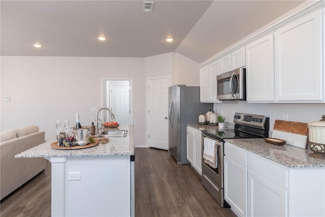 kitchen with visible vents, a kitchen island with sink, a sink, white cabinetry, and appliances with stainless steel finishes