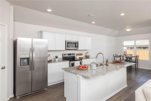 kitchen with a sink, appliances with stainless steel finishes, white cabinets, and an island with sink