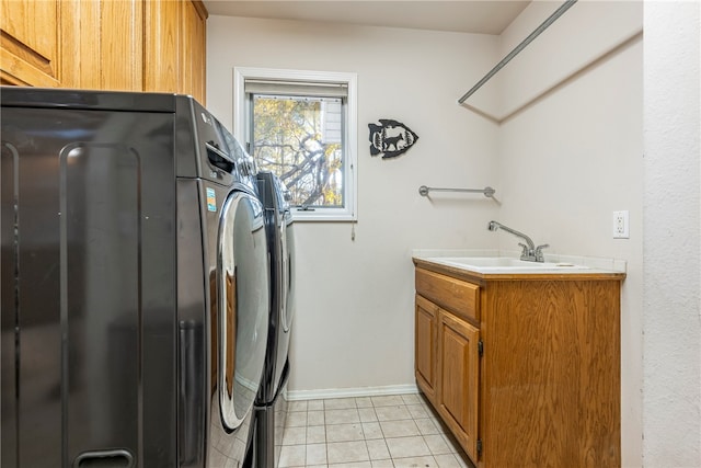 clothes washing area with washer and clothes dryer, light tile patterned flooring, cabinets, and sink