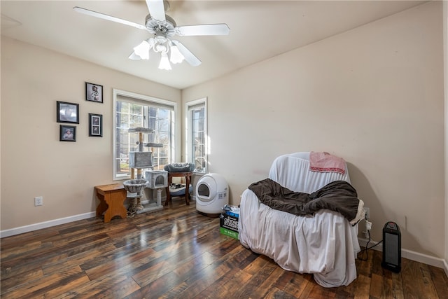 living area with ceiling fan and dark wood-type flooring