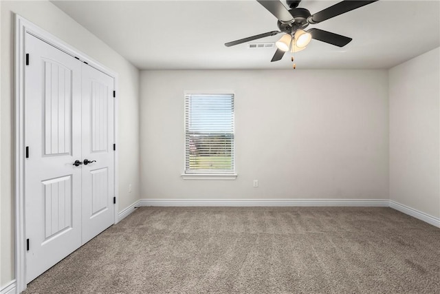 unfurnished bedroom with light colored carpet, a closet, and ceiling fan