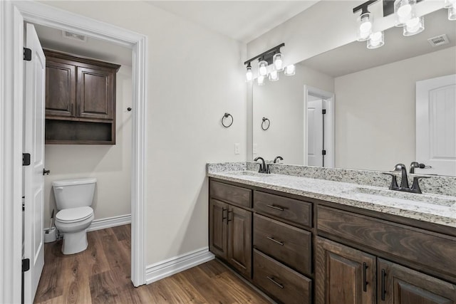 bathroom featuring wood-type flooring, vanity, and toilet