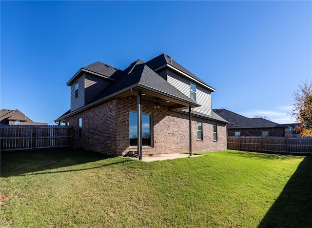 back of house with a lawn and a patio area