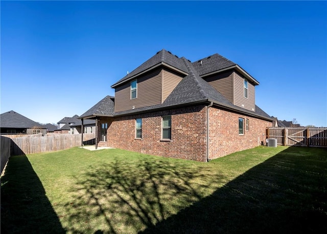 back of house featuring central AC and a yard