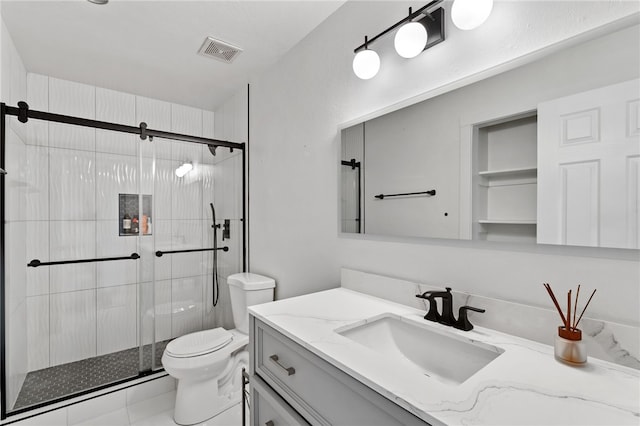 bathroom with tile patterned floors, vanity, toilet, and a shower with door