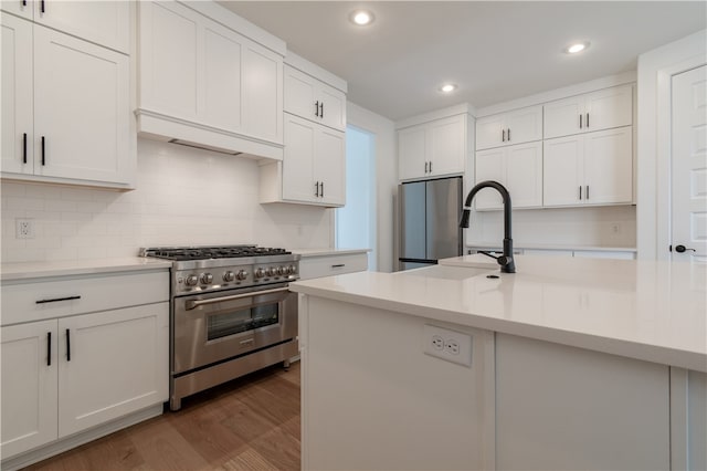 kitchen featuring decorative backsplash, appliances with stainless steel finishes, sink, white cabinets, and dark hardwood / wood-style floors