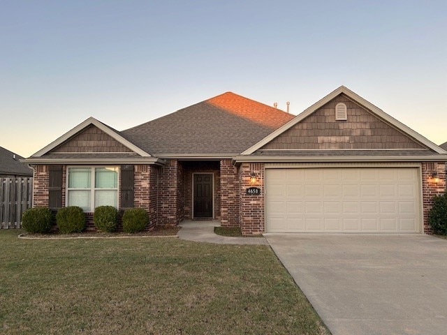 view of front facade featuring a garage and a lawn